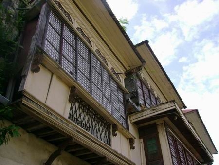 Philippine baroque: adobe ground floor; wooden second floor projecting over the sidewalk -- classic bahay-na-bató design!